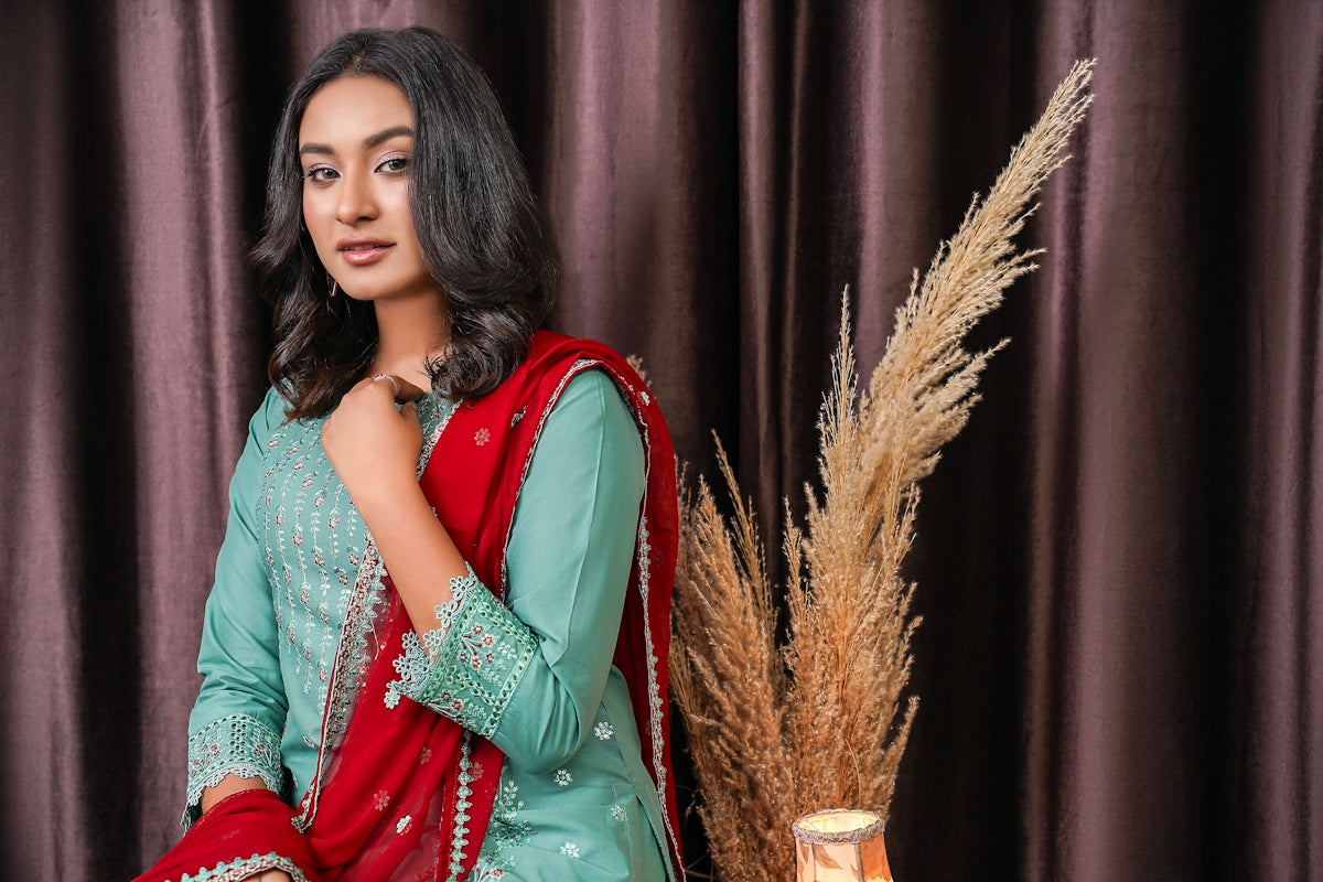 a woman in a green and red dress posing for a picture